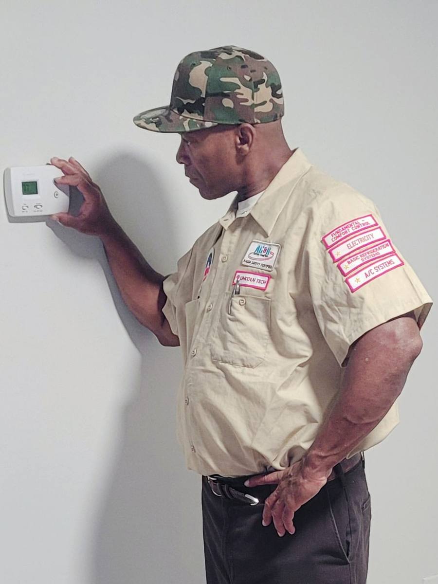 Dunell Do All technician checking a thermostat